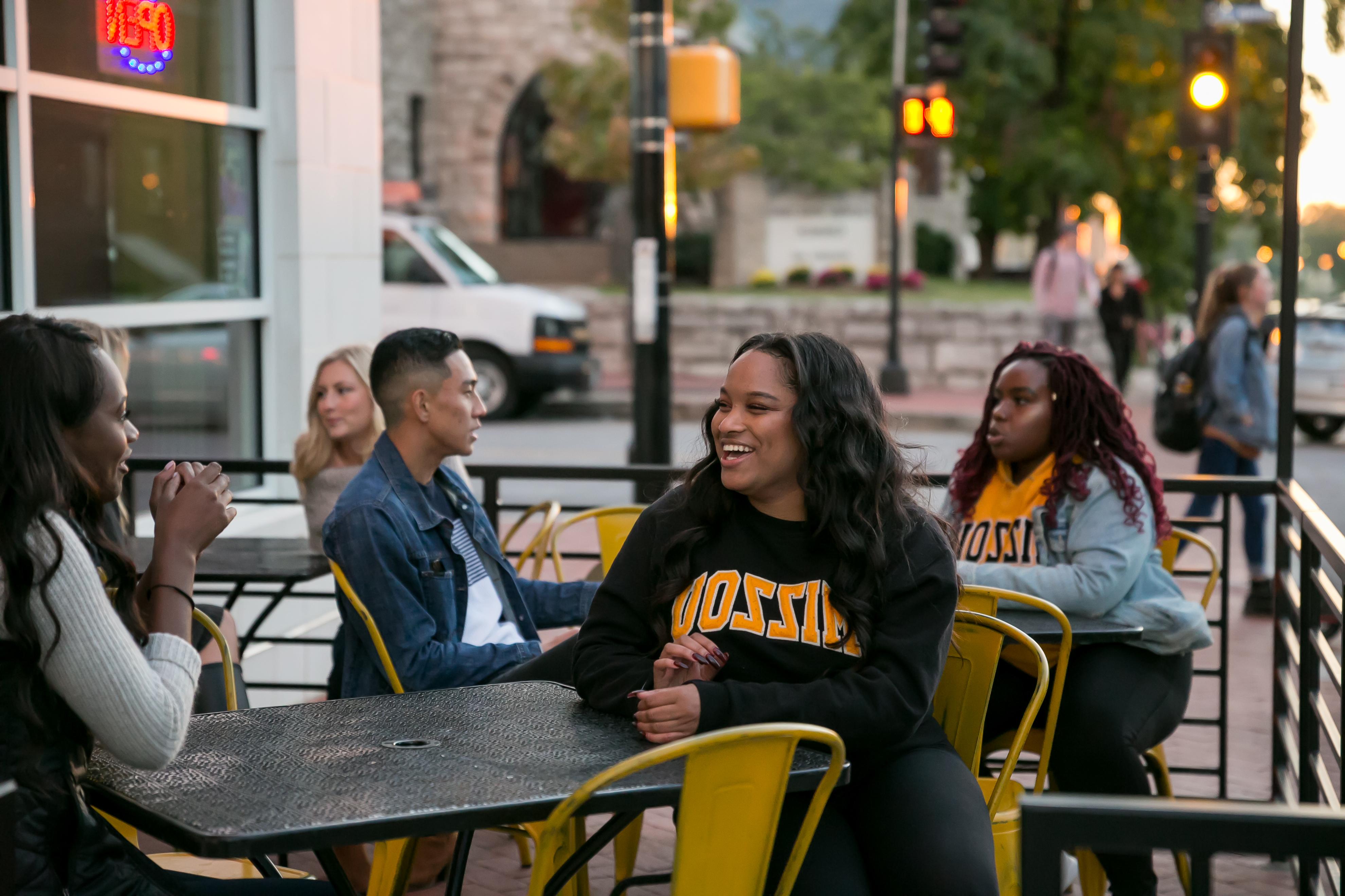 Students sitting at outdoor tables in downtown Columbia